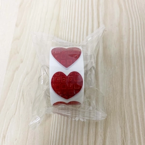 Detail of red heart-shaped sticker roll with grid texture for gift packaging and DIY