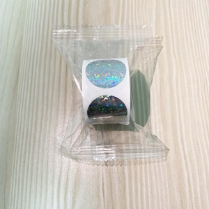 Macro detail of holographic glitter round stickers in light blue and grey rolls