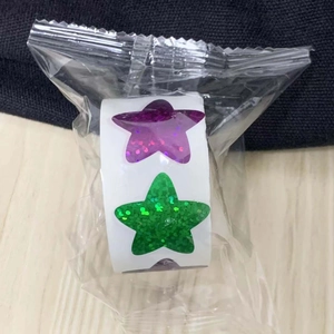 Detailed macro of glitter star stickers roll in vibrant purple and green colors