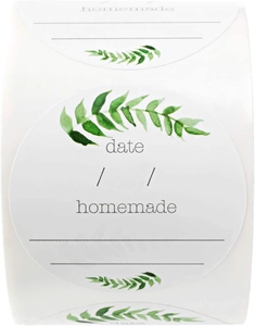 Detail of round white homemade stickers with green leaves and date field on roll