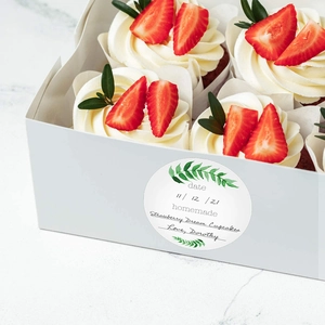 Handmade brown kraft stickers featuring a green leaf pattern on a strawberry cupcake box