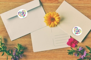 Colorful paw print heart stickers on white envelopes and wooden desk for decoration
