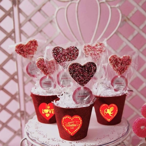 Macro shot of heart-shaped chocolate pops with colorful sprinkles in a festive gift pot