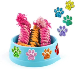 Détail d'un bol bleu avec jouets en corde tressée et autocollants de pattes à paillettes