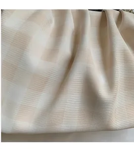 Détail du tissu tissé à carreaux crème et de la texture douce de ce sac à main chic