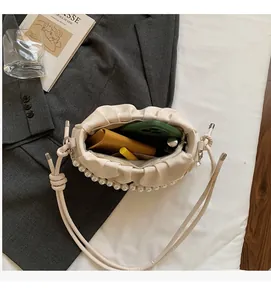 Vue de dessus d'un sac nuage blanc crème avec perles montrant l'espace de rangement interne