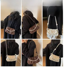 Détails de la chaîne en perles et texture plissée sur un sac à bandoulière épuré