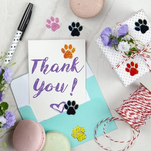 Vue macro de stickers pattes multicolores pailletés pour coffrets cadeaux et enveloppes