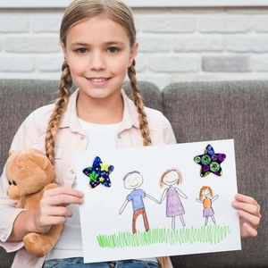 Child holding colorful holographic star stickers with rainbow laser glitter patterns