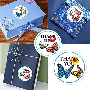 Colorful butterfly thank you stickers shown on gift boxes and envelopes for wedding favors
