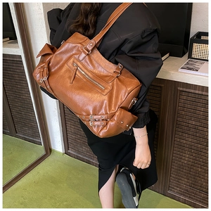Detail showing vintage caramel brown leather tote bag with functional zipper pockets