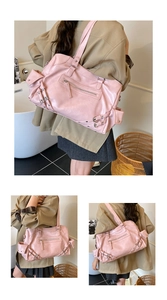 Macro view of a large pink glossy leather tote bag with silver buckles and zippers