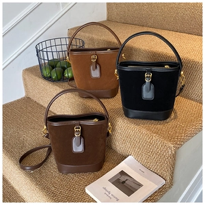 Drei Vintage-Beuteltaschen in Hellbraun, Dunkelbraun und Schwarz auf Treppen in warmer Optik