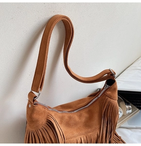 Dettaglio borsa a tracolla marrone con frange in pelle scamosciata e stile bohémien