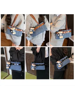 Détail du sac à bandoulière en denim avec sangle en cuir et charmant petit ours