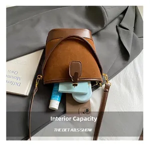 Macro view of brown suede bucket bag interior showing spacious storage for phone and makeup