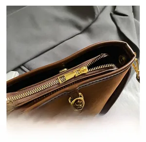 Detail view of smooth metal zipper and premium gold hardware on brown bucket bag