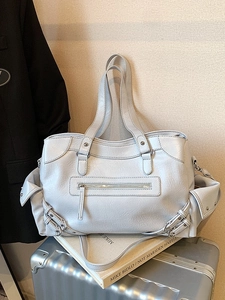 Large beige motorcycle style tote bag with lychee texture on silver suitcase