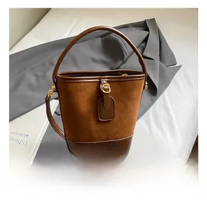 Detail showing the spliced suede and leather texture on a brown vintage bucket bag handle