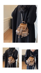 Detail of vintage brown leather backpack with white stitching and front flap pockets