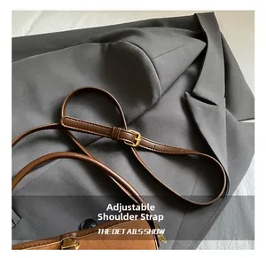 Close-up of adjustable brown leather shoulder strap with premium gold metal buckle