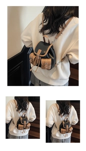 Detailed view of a vintage mini backpack with black fabric and brown leather piping accents