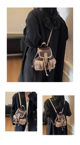 Detail of vintage faux leather mini backpack featuring drawstring and metallic buckles