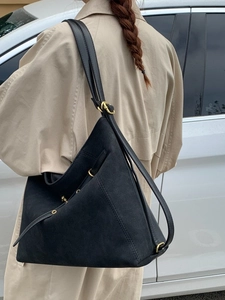 Minimalist black large capacity tote bag with matte finish and gold metal hardware buckles
