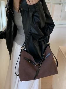 Large casual tote bag in brown textured fabric with black leather straps and gold buckle