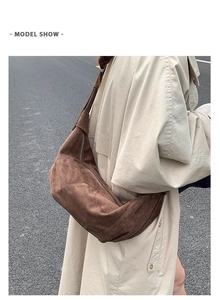 Détail d'un sac bandoulière en daim marron foncé porté avec un trench-coat beige d'automne