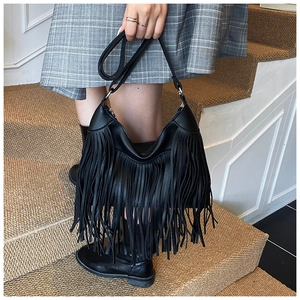 Détail du sac seau noir en cuir grainé avec de longues franges de style bohème