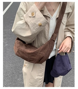 Sac demi-lune en daim marron et casquette violette dans un décor de style urbain