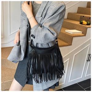 Détail du cuir noir grainé et des franges élégantes sur ce sac à bandoulière chic