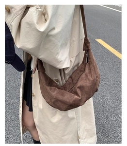 Sac hobo en daim marron porté avec un trench beige pour un look d'automne élégant