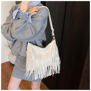 Gros plan détaillé du sac seau en cuir PU crème orné de longues franges bohèmes