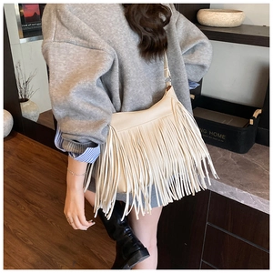 Détail du sac seau bandoulière blanc cassé avec franges bohèmes et texture cuir souple