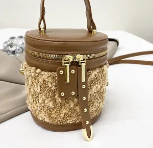 Detail eines glatten Gold-Reißverschlusses an der braunen Leder-Plüsch-Eimertasche
