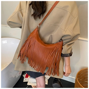 Sac hobo marron rétro avec longues franges et bandoulière réglable porté par un mannequin