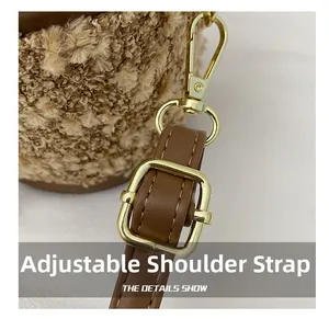 Detail eines verstellbaren braunen Lederriemens mit goldener Schnalle an Plüschtasche