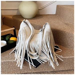 Détail d'un sac demi-lune beige à franges en cuir synthétique avec boucles métalliques