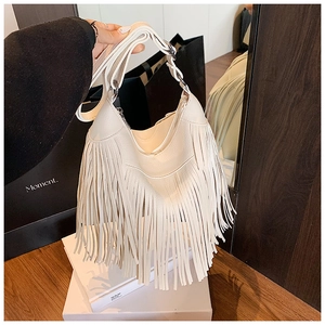 Gros plan détaillé du sac seau beige crème avec de longues franges de style bohème