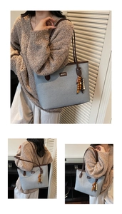 Detail of light blue fabric tote bag with brown leather trim and beaded tassel charm