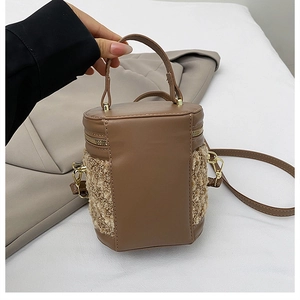 Detalle del bolso de cubo en contraste con ribete de cuero marrón y textura de pelo beige