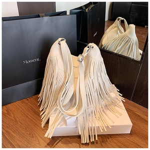 Vue détaillée du sac seau à franges crème avec cuir grainé et garnitures argentées