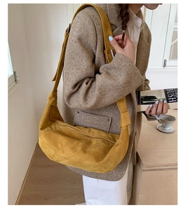Détail d'un sac hobo en daim jaune gingembre avec large bandoulière au style décontracté