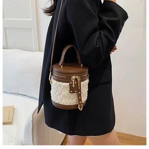 Detail einer braunen Leder- und weißen Fleece-Beuteltasche mit goldenem Reißverschluss