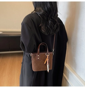 Dettaglio mini borsa a secchiello trapuntata marrone con ciondolo di perline colorate