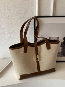 Minimalist off-white canvas tote bag with brown leather handles and gold metal lock detail