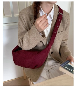 Détail du sac croissant en daim bordeaux avec bandoulière réglable et boucle argentée