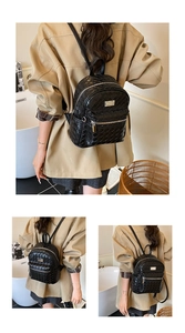 Détail d'un sac à dos noir avec texture tressée, fermeture éclair métallique et poche avant